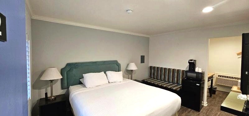 King guest room with white bedding and seating area